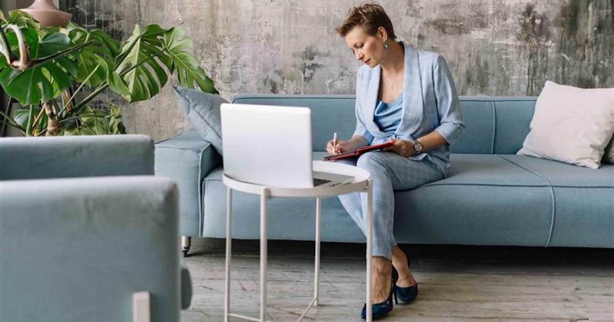 Person sitting on a couch while looking at a computer