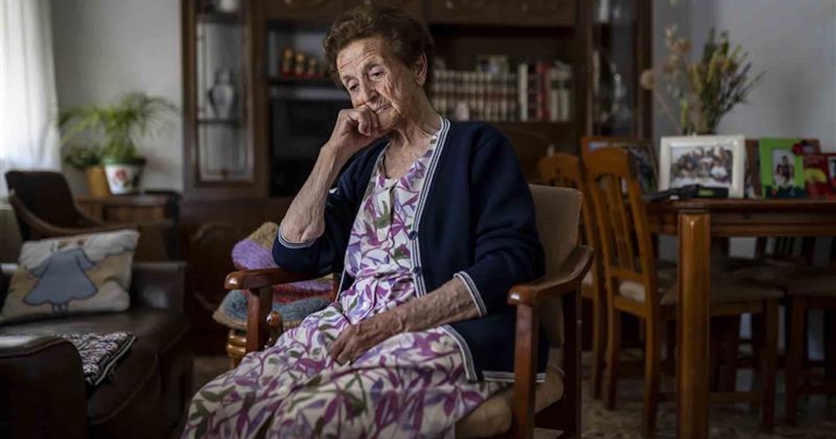 Older woman sitting in her living room pensive and depressed Older woman sitting in her living room pensive and depressed