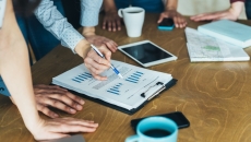 Photo of people reviewing data/charts/graphs