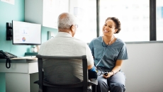 Healthcare provider with a patient sitting next to a computer