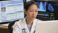 Healthcare professional reviewing patient data on a PC