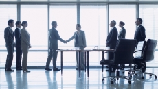 Business representatives shake hands to close a deal