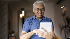 Person smiling while using a smart tablet