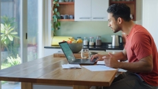 Person sitting at a table while looking at a computer