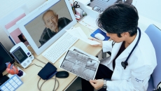Doctor doing telehealth while looking at x-ray scans