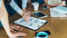 A close-up of workers looking at financial charts