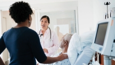A doctor talking to patient and his family in a hospital room.