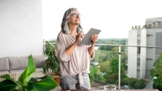 A woman standing at her desk using a tablet