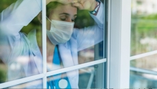 Tired doctor looking out of window