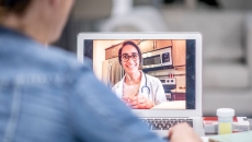 A person talking a doctor via a video chat on their laptop.