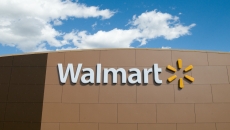 Walmart store front with the Walmart logo and the blue sky above the store