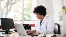Healthcare provider sitting at a desk and looking at a computer