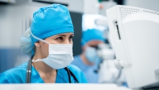 Surgeon in an operating room looking at a computer screen