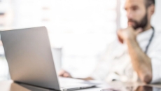 Healthcare provider sitting at a desk with a computer on it