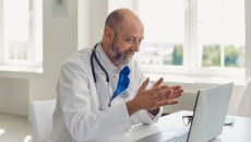 Doctor sitting at a desk while looking at a computer screen