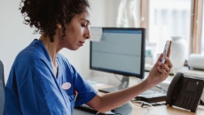 A doctor talking to a patient through a video call on her smartphone