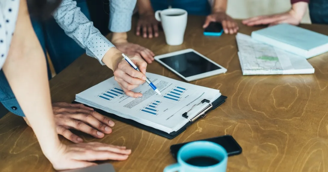 Photo of people reviewing data/charts/graphs