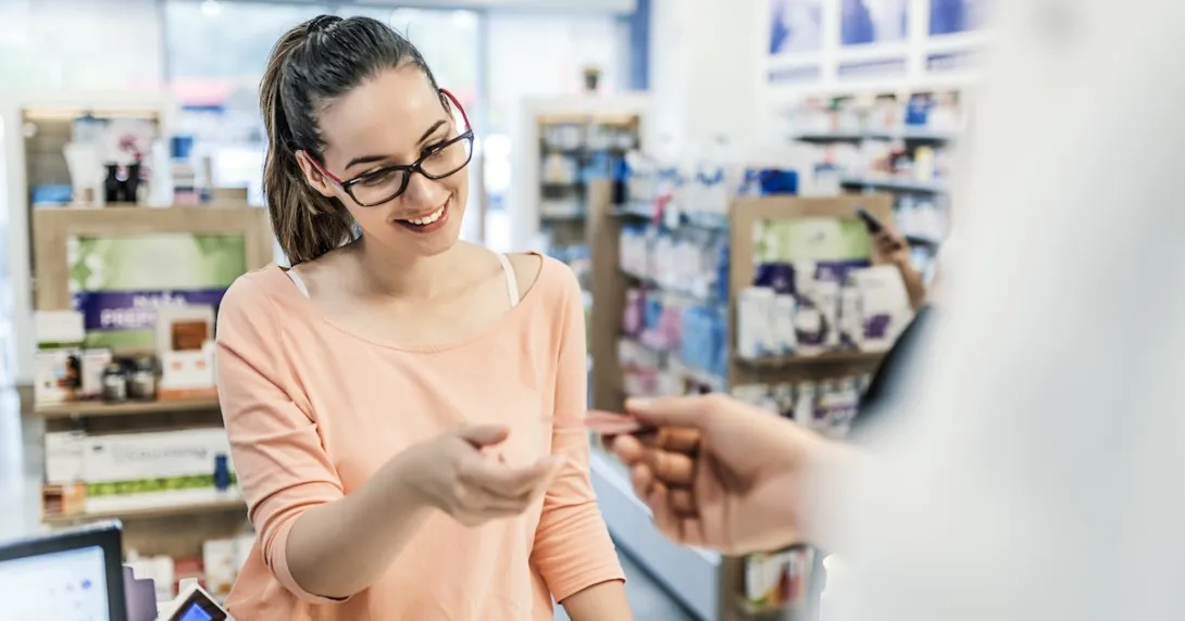 Patient picking up a prescription at a retail pharmacy