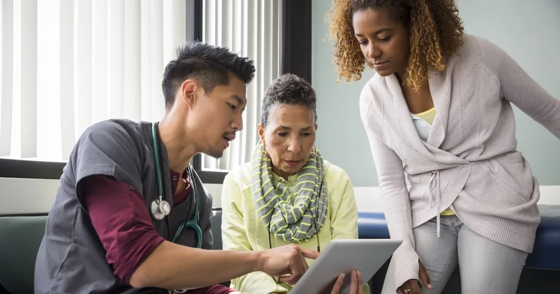 Healthcare professional two people looking at data on a tablet