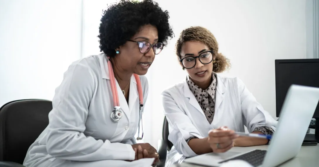 Two healthcare providers on a computer