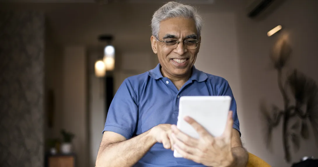 An elderly using a digital tablet at home