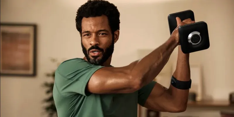 A man lifting a weight wearing the heart rate monitor