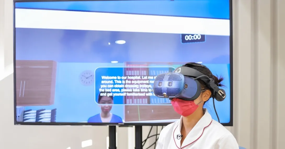 A nursing student wearing a VR lens demonstrates the use of the Virtual Hospital learning system