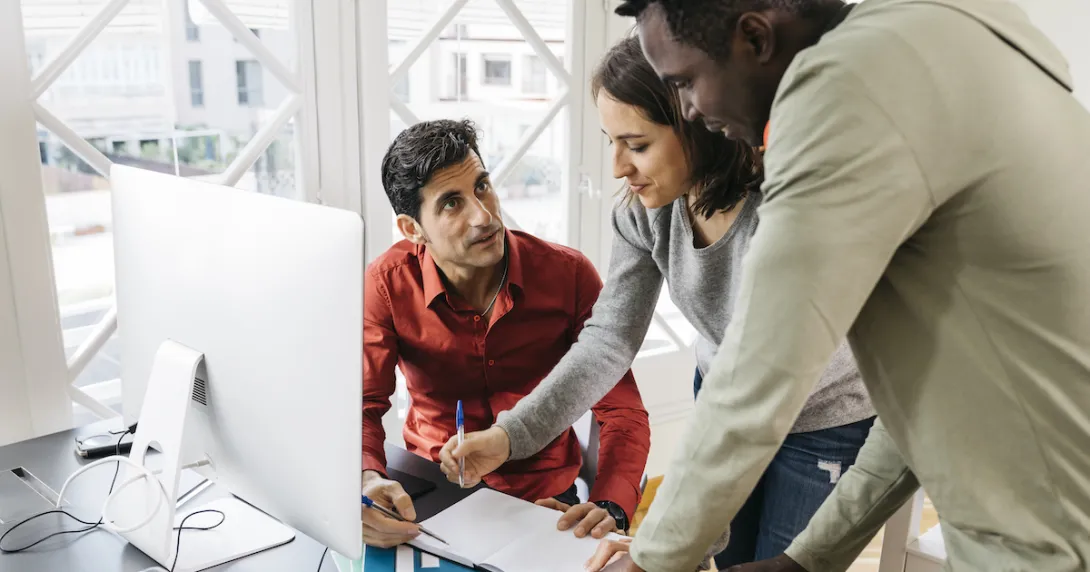 People in an office at a desk talking