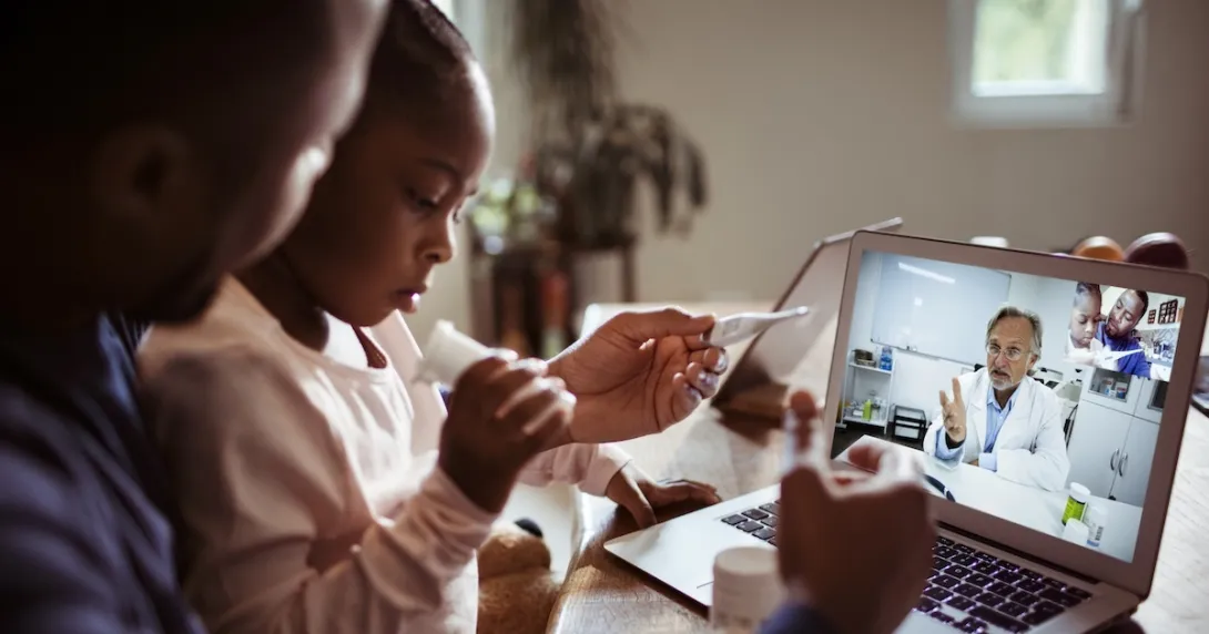 Two people conferring with a healthcare professional via a laptop computer