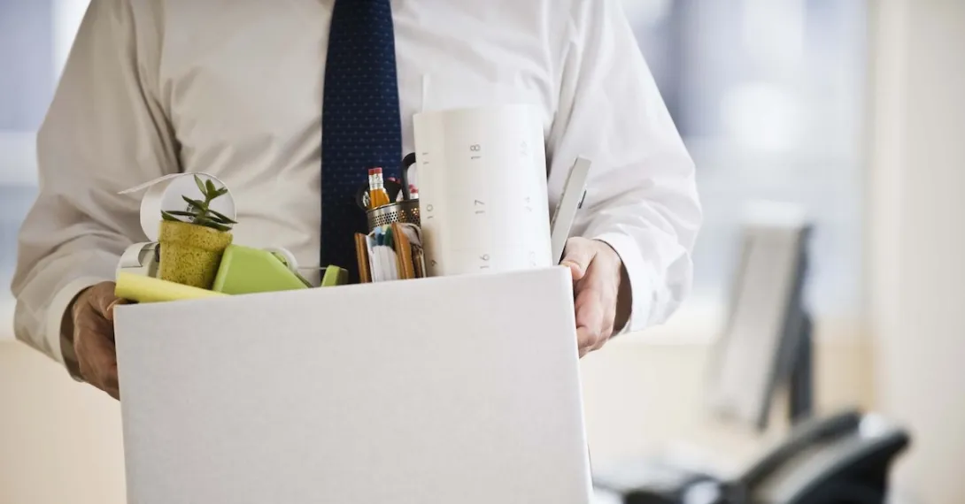 A worker holding a box with belongings