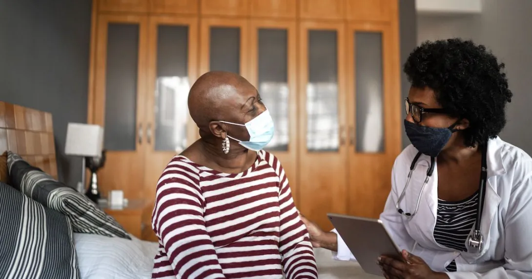 A cancer patient talking to a provider in her home.