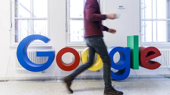 A man walks by a Google logo
