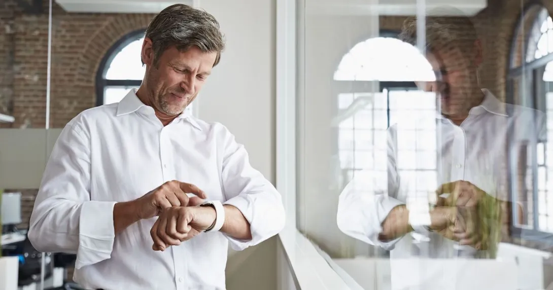 A man using a smartwatch in an office.