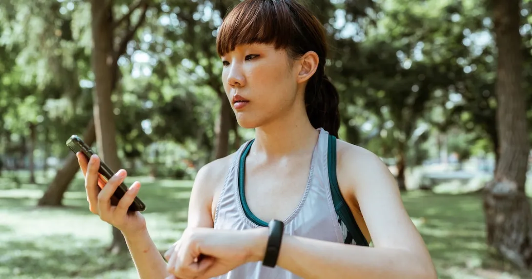 A person using a fitness tracker and mobile app to monitor her health goals