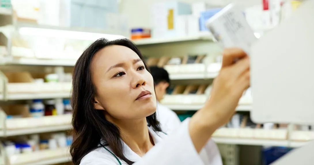 A pharmacist pulling a medication off a shelf
