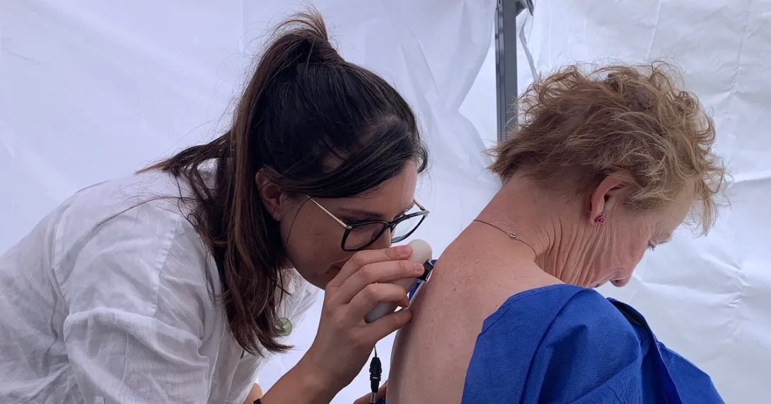 A nurse conducting a skin check using AI in a pop-up clinic