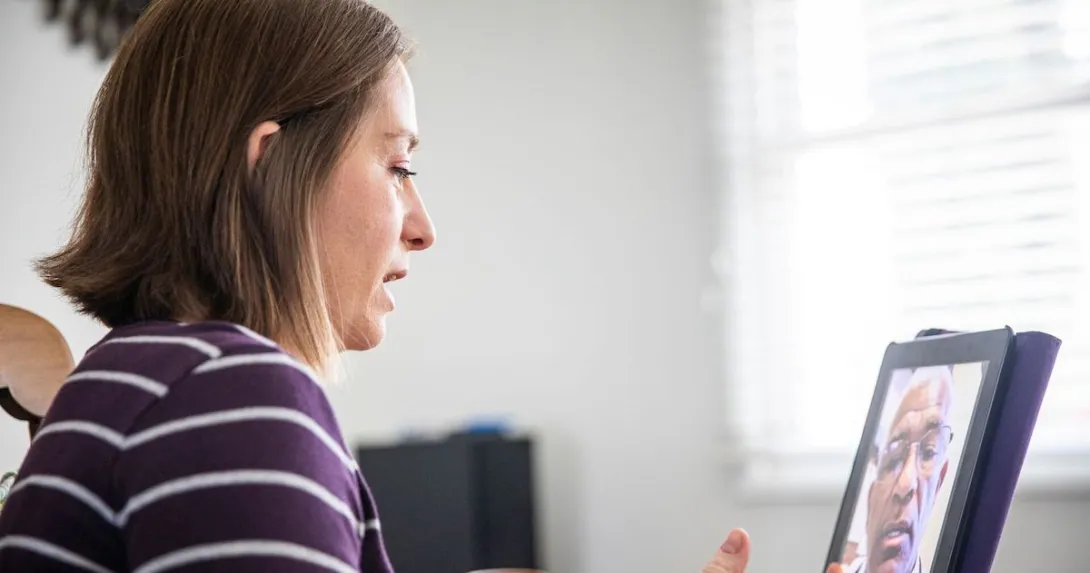 A woman talking to a provider via a video call on her tablet.