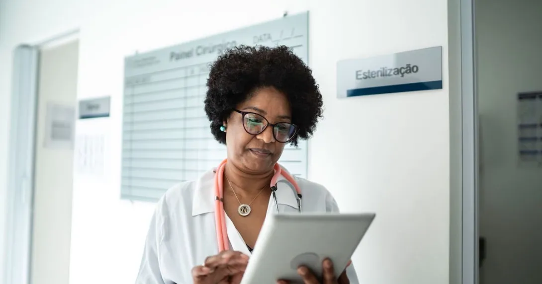 Healthcare provider on a tablet walking through a clinic