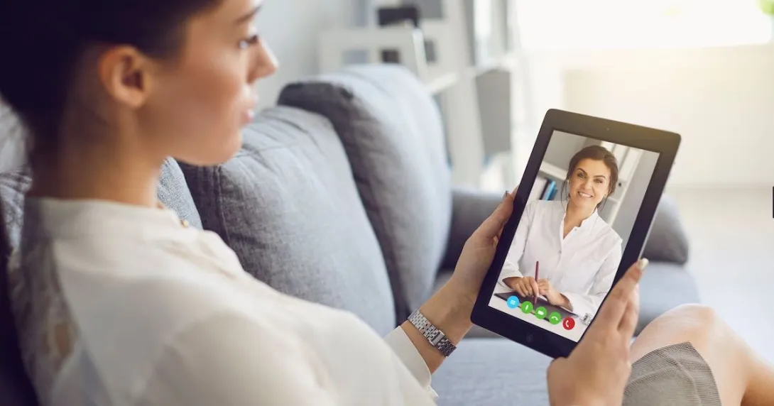 A woman talking to a provider on a tablet
